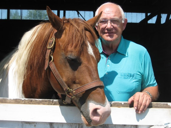 Man standing beside a horse